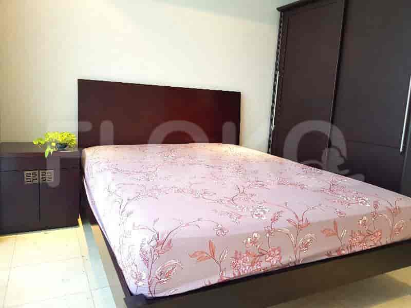 A bedroom with a queen-sized bed, a dark wood headboard, and a matching bedside table.