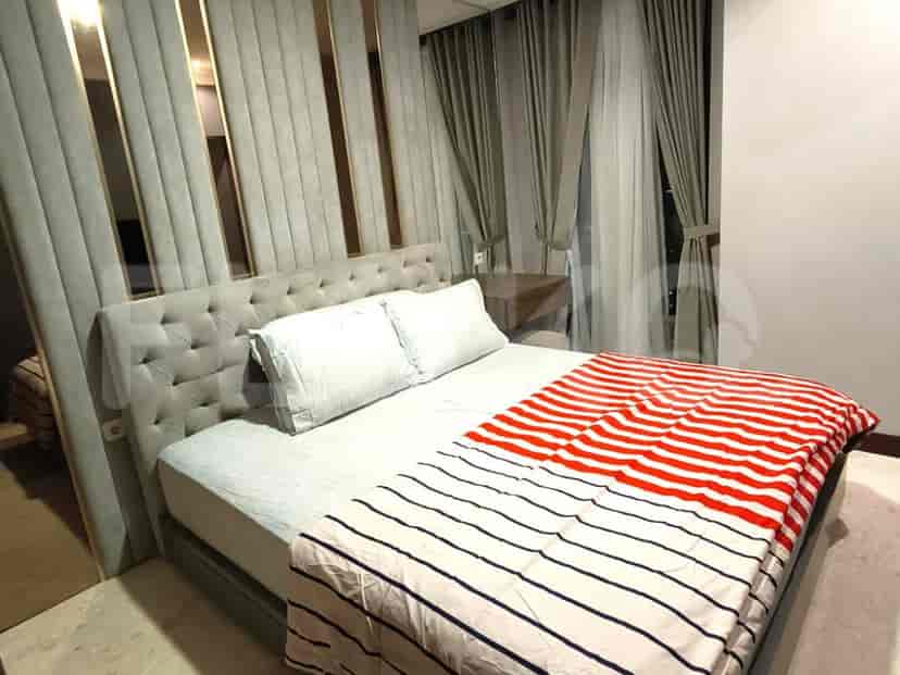 A bedroom with a king-size bed, tufted headboard, and bedside tables.