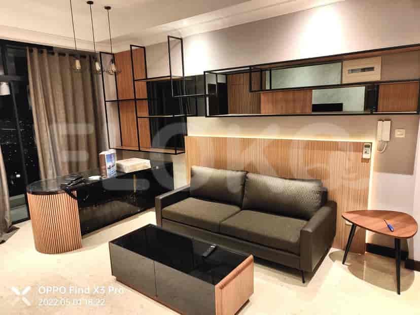 A modern living area with a dark desk, a grey sofa, and contemporary shelving.