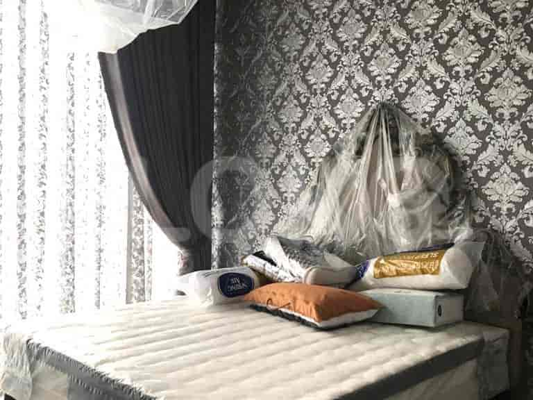 A bedroom with a bed covered in plastic, pillows, and curtains.