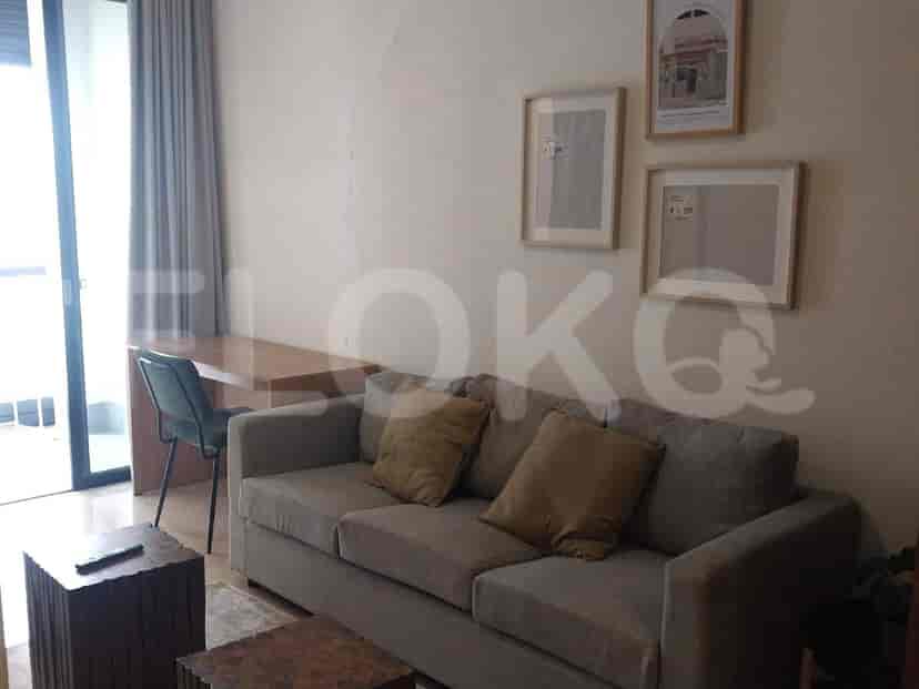 Living room with a grey sofa, coffee table, desk, and chair.