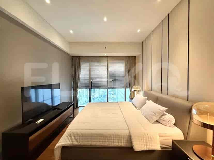 A master bedroom featuring a large bed, a wall-mounted TV, and expansive windows with city views.