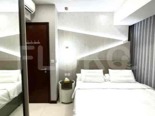 A bedroom with a bed, a mirrored closet, and a decorative wall.