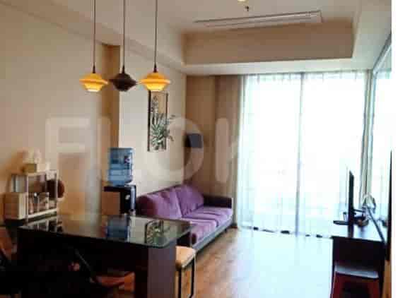 A living room with a purple sofa, a dining table, and a water dispenser.