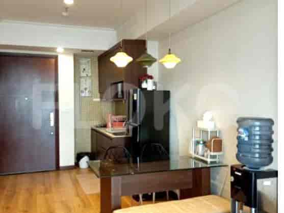 A kitchen and dining area with cabinets, a refrigerator, and a dining table.