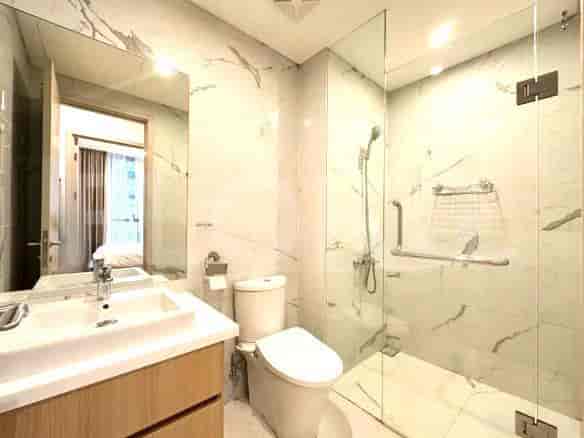 A modern bathroom with marble-effect tiles, a walk-in shower, and a vanity.