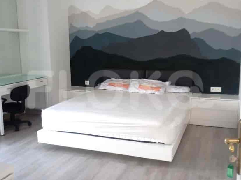 A bedroom with a large bed, bedside tables, and a mountain-themed mural.