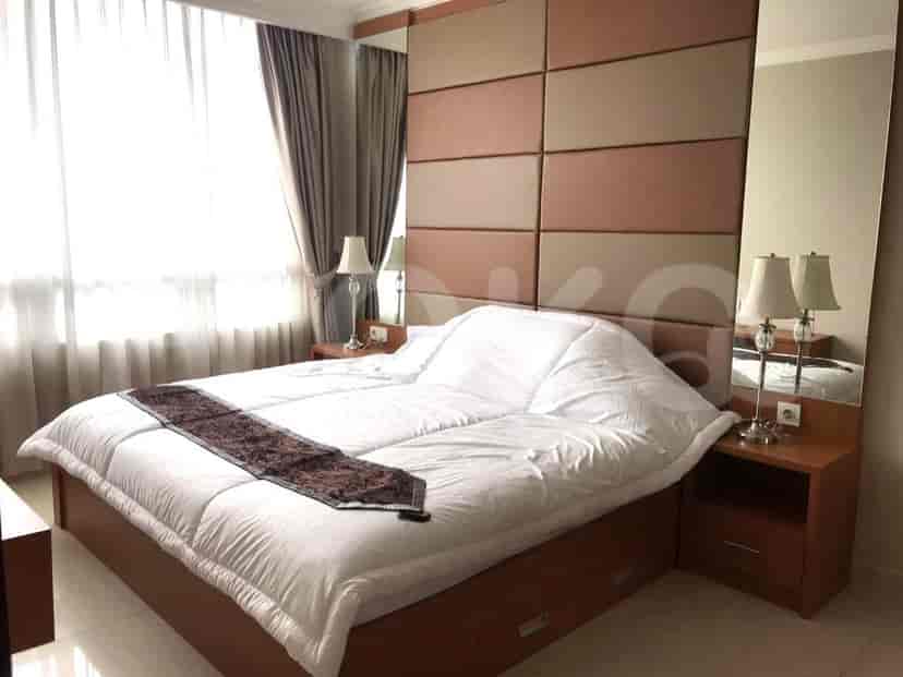 A bedroom with a large bed, nightstands, and mirrors.