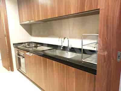 A modern kitchen with wooden cabinets, a black countertop, a gas stove, a sink, and a faucet.