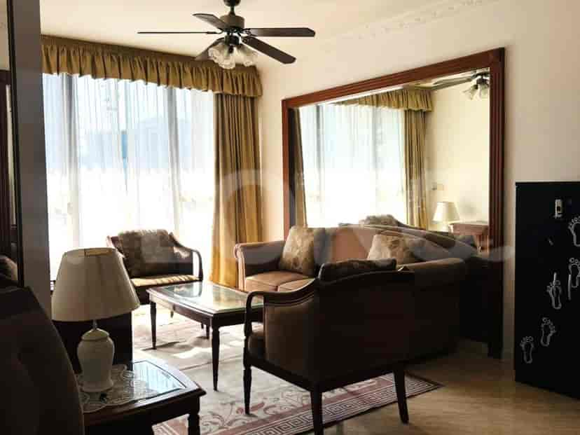 A spacious living room with a large mirror, sofa, armchair, coffee table, and ceiling fan.