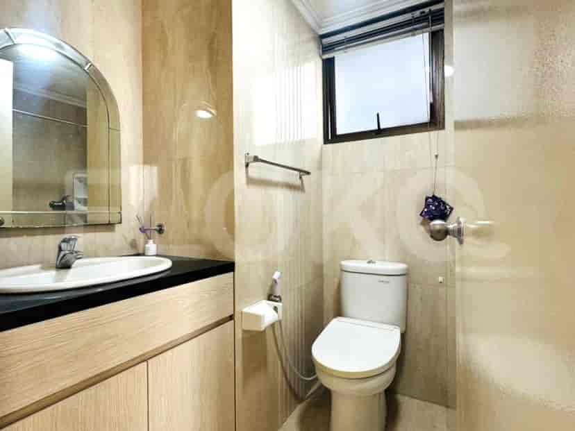 A compact bathroom with a toilet, sink, vanity, and a mirror.
