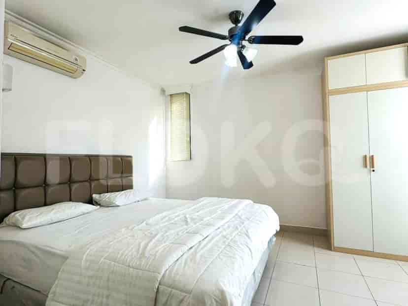 A master bedroom with a large bed, air conditioning unit, ceiling fan, and a wardrobe.