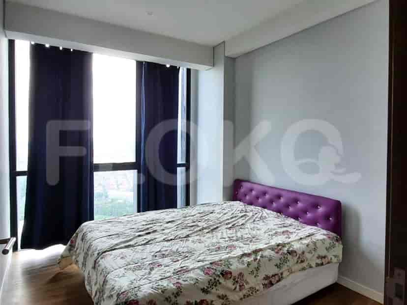 Sebuah kamar tidur dengan tempat tidur ukuran queen dan gorden biru tua.