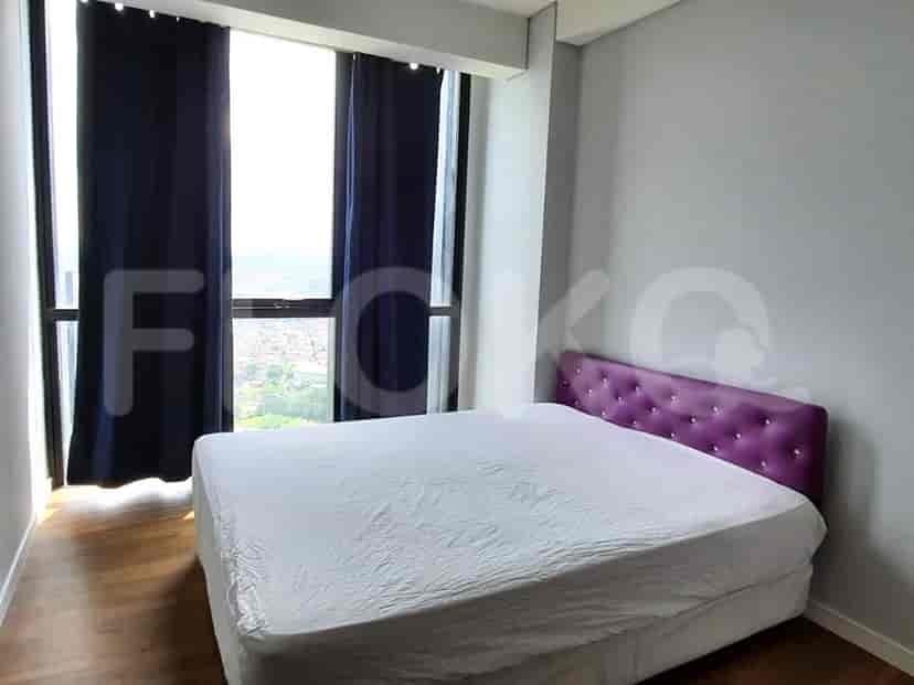 Sebuah kamar tidur dengan tempat tidur ukuran queen dan gorden biru tua, menampilkan seprai putih.