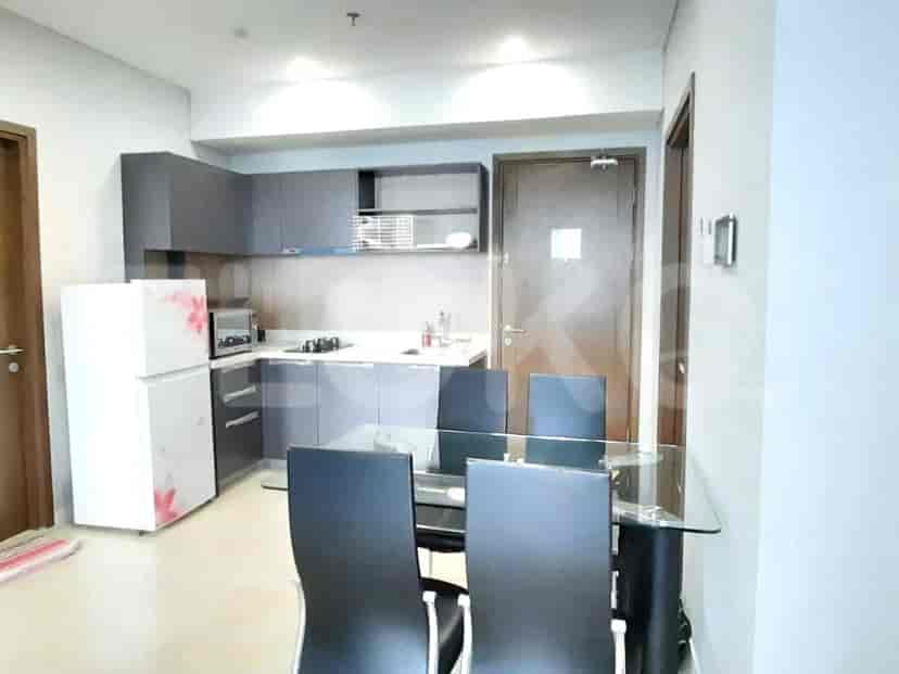 Area dapur dan ruang makan dengan meja makan bergelas dan kursi.