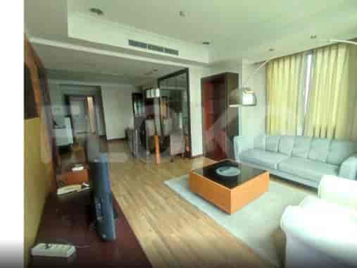 A living room with a grey sofa, coffee table, and a television set.