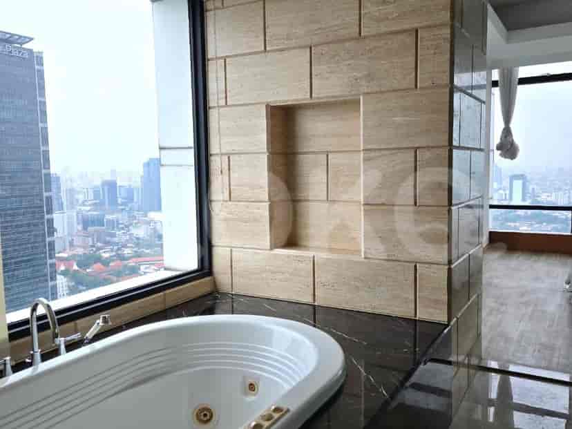 A luxurious bathroom with a freestanding bathtub and a tiled accent wall.