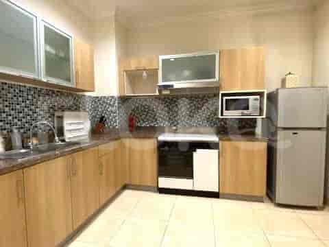 Dapur modern dengan kabinet kayu terang, meja granit, dan peralatan stainless steel.