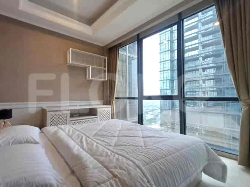 A bedroom with a large bed and expansive windows offering a city view.