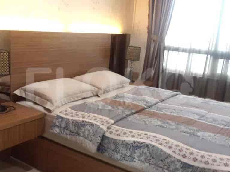Bedroom with wooden bed and bedside tables, creating a warm atmosphere.