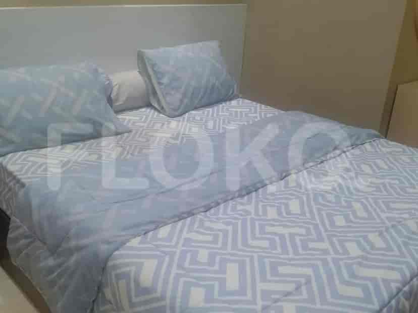 A bedroom with a bed and light blue patterned bedding.