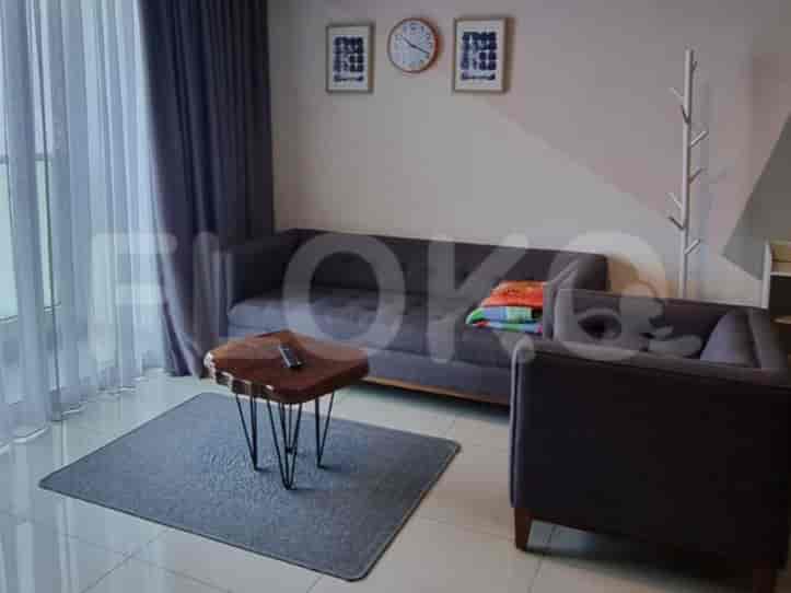 A living room with a grey sofa, coffee table, rug, and decorative wall art.