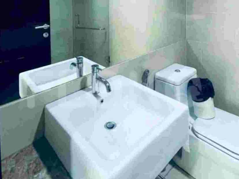 A clean bathroom with a sink, toilet, and mirror.