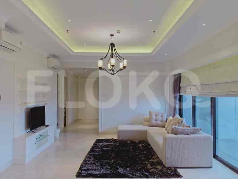 A spacious living room with a large sectional sofa, a sleek TV console, and a dark rug.