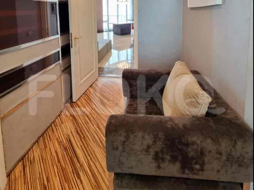 A hallway with a small sofa and a door.