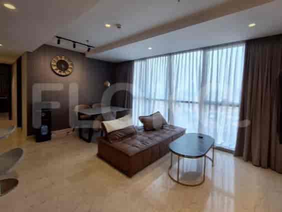 A living room with a brown sofa, coffee table, dining table, and a water dispenser.