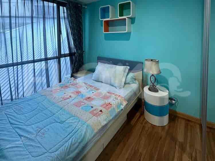 Kamar tidur anak dengan tempat tidur tunggal, dinding biru cerah, dan rak.