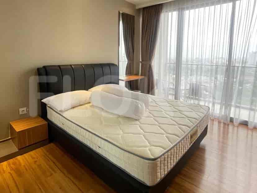 A view of the bed and the large window with curtains.
