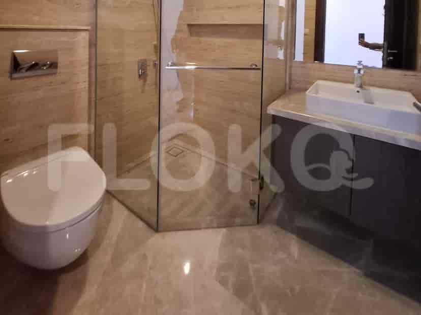 Modern bathroom with a glass shower, toilet, and vanity with a large mirror.