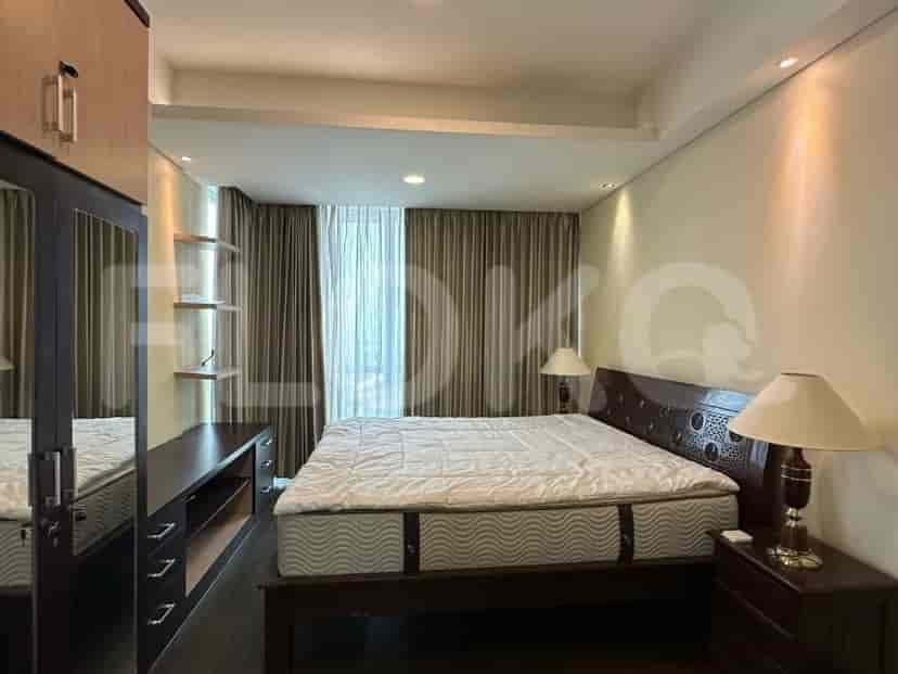 A master bedroom with a king-size bed, wooden headboard, nightstands with lamps, and a large window with textured curtains.