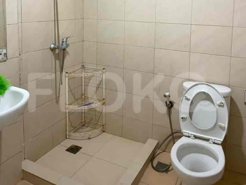 A bathroom with a toilet, a shower area, and a sink.