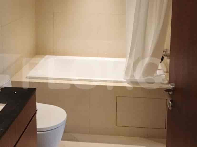 Kamar mandi dengan bak mandi, toilet, dan dinding berubin.