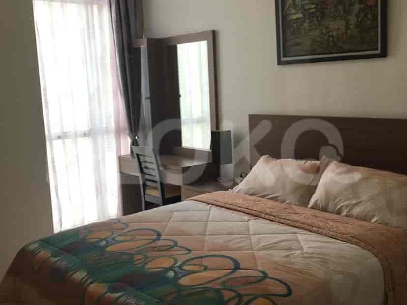 A cozy bedroom with a queen-size bed, a vanity with a mirror, and a window with curtains.