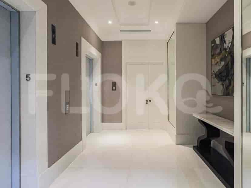 A hallway with elevators, white marble flooring, and a modern aesthetic.