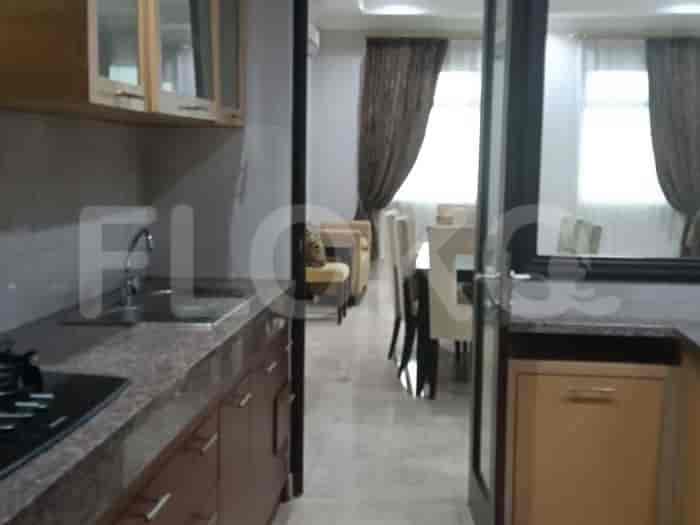A compact kitchen with granite countertops, wooden cabinets, and a sink with a faucet.