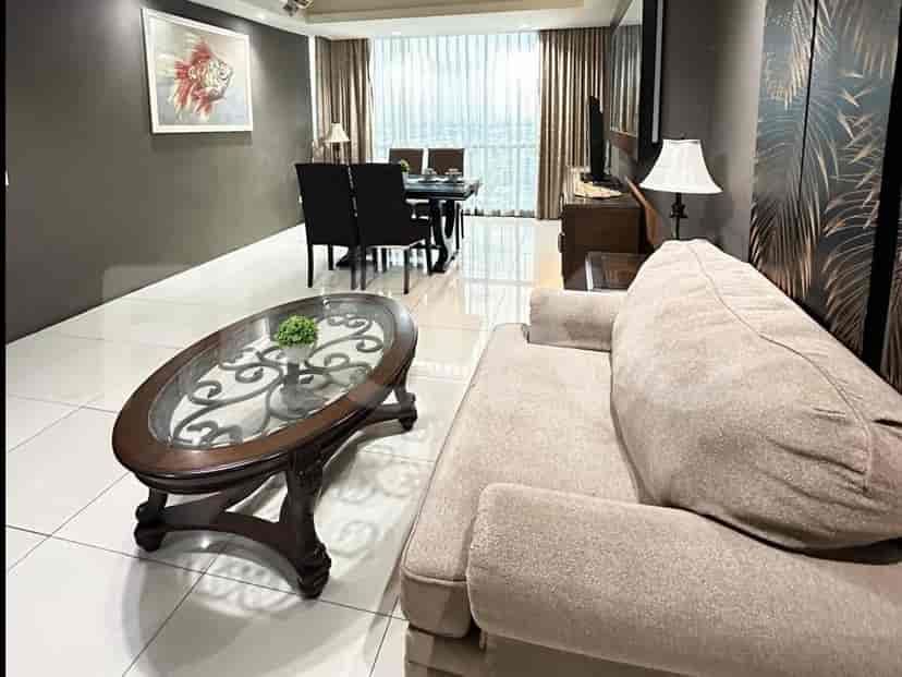 A combined living and dining area with a sofa, coffee table, dining table, and a painting on the wall.