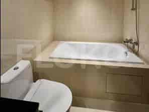 Kamar mandi yang bersih dan modern dengan bak mandi, toilet, dan dinding berubin.
