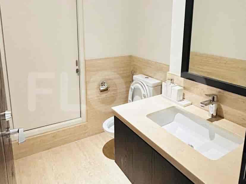 A contemporary bathroom featuring a vanity with a vessel sink, a toilet, and a glass-enclosed shower.