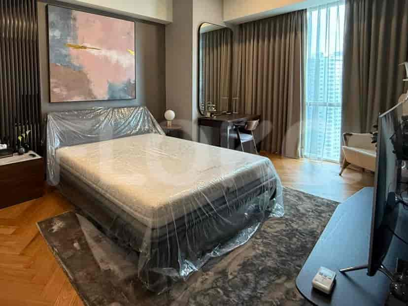 A master bedroom with a large bed, a vanity area, and a walk-in closet, all decorated in a sophisticated style.