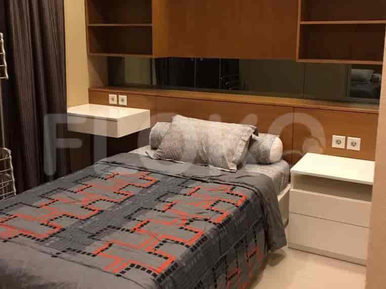Bedroom with a bed, bedside tables, and a wall-mounted headboard.