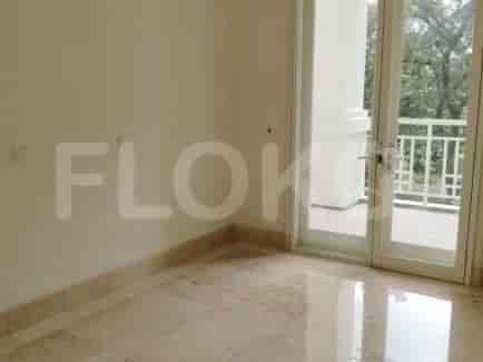 A bedroom with a glass door leading to a balcony, marble floors, and white walls.