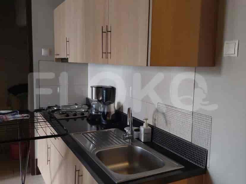 A kitchen area with cabinets, a sink, a stove, and a coffee maker.