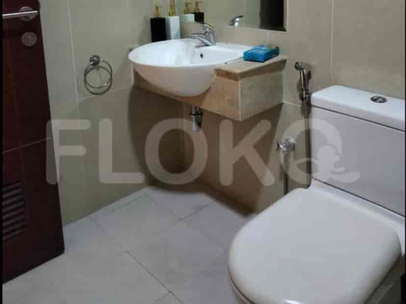 A bathroom with a white toilet, sink, and neutral color scheme.