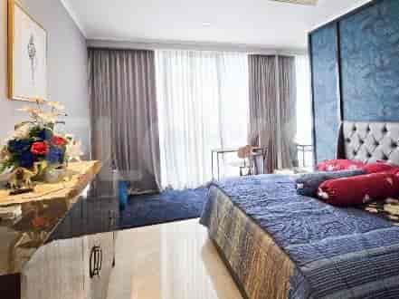 A well-lit bedroom with a large bed, blue and grey color scheme, and floor-to-ceiling windows.