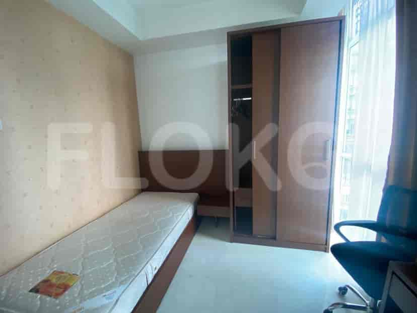A single bed in a bedroom with a wardrobe and a window.