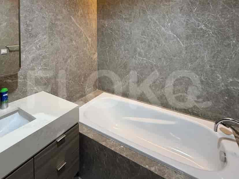 Kamar mandi dengan bak mandi dan finishing marmer.